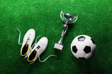 Futbol topu, kramponlar ve kupa  