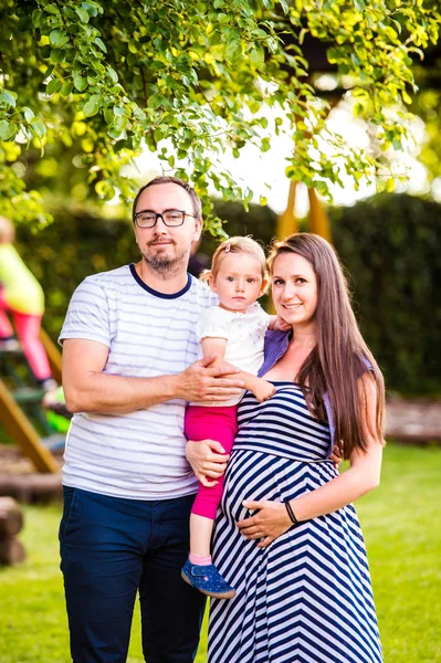 Young family outside in sunny summer park, green nature — Stock Photo, Image