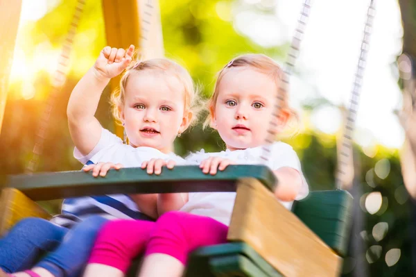 두 아름 다운 소녀는 공원에서 스윙. — 스톡 사진