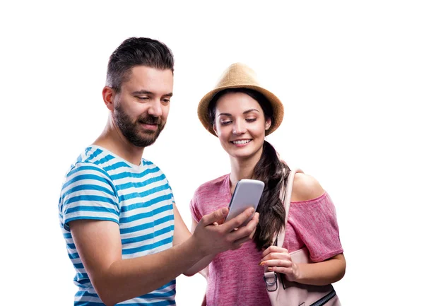 Пара в летней одежде со смартфоном, делающая селфи — стоковое фото