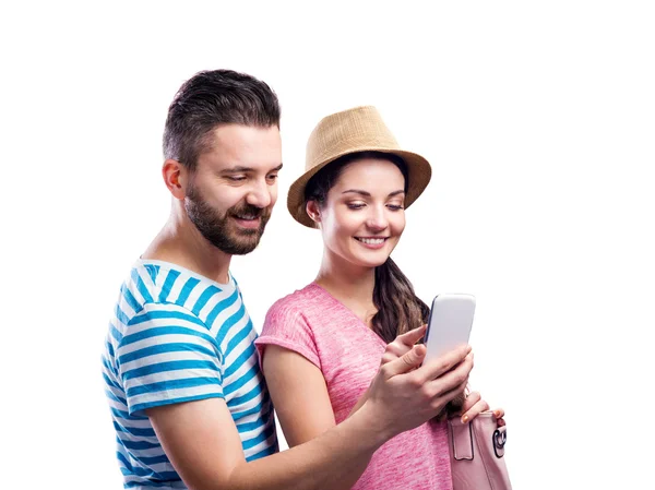 Пара в летней одежде со смартфоном, делающая селфи — стоковое фото