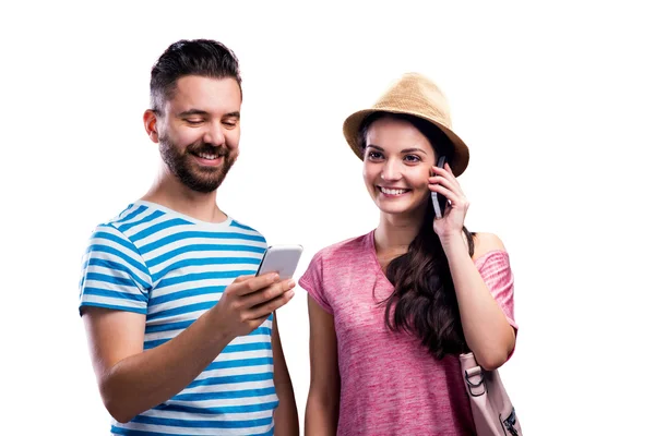 Couple in summer clothes with smartphones, texting, phone call — Stock Photo, Image