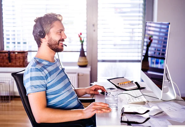 Man sitting at desk working from home on computer — Stock Photo, Image
