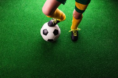 Tanınmayan küçük futbol oyuncu yeşil çimen, studi karşı