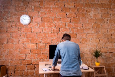 Ofis masasında duran üzgün işadamı, arka görüş