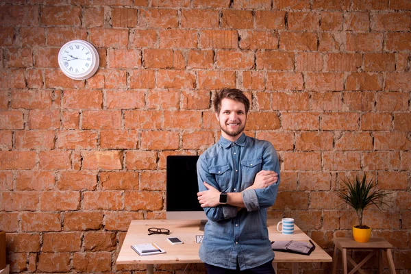 Business person sitting on office desk wearing smart watch