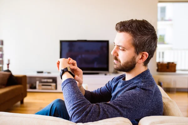 Man working from home using smart watch, living room — Stock Photo, Image