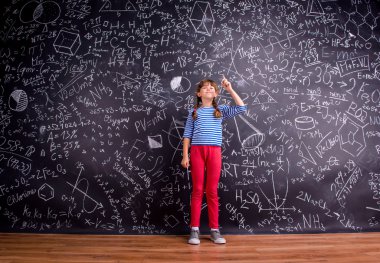 Girl with two braids, big blackboard with mathematical symbols