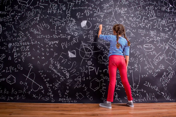 Ragazza con due trecce, scrivendo su una grande lavagna — Foto Stock