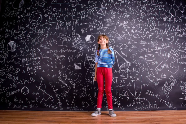 Mädchen mit zwei Zöpfen, große Tafel mit mathematischen Symbolen — Stockfoto