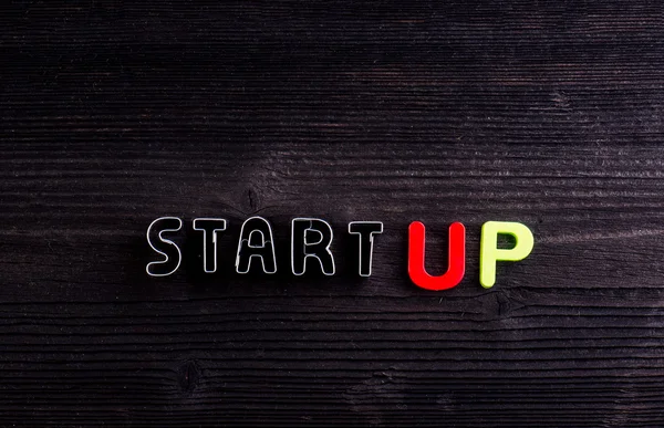 Start up sign made of cookie cutters. Wooden background. — Stock Photo, Image