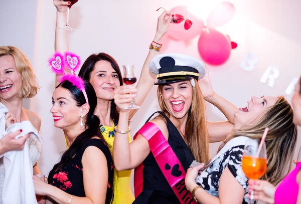 Cheerful bride and bridesmaids celebrating hen party with drinks — Stock Photo, Image