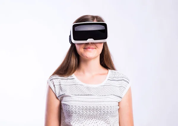 Kobieta z goglami wirtualnej rzeczywistości. Studio shot, szare tło — Zdjęcie stockowe