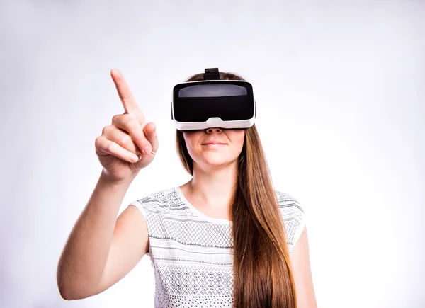 Mujer con gafas de realidad virtual. Estudio de tiro, fondo gris —  Fotos de Stock