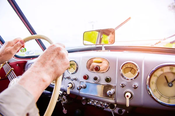 Primer plano hombre irreconocible conduciendo un coche veterano — Foto de Stock