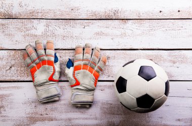 Futbol topu, beyaz ahşap zemin üzerinde eldiven, stüdyo atış
