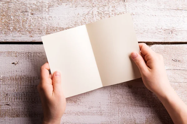 Mujer irreconocible sosteniendo una tarjeta de felicitación vacía. Captura de estudio — Foto de Stock