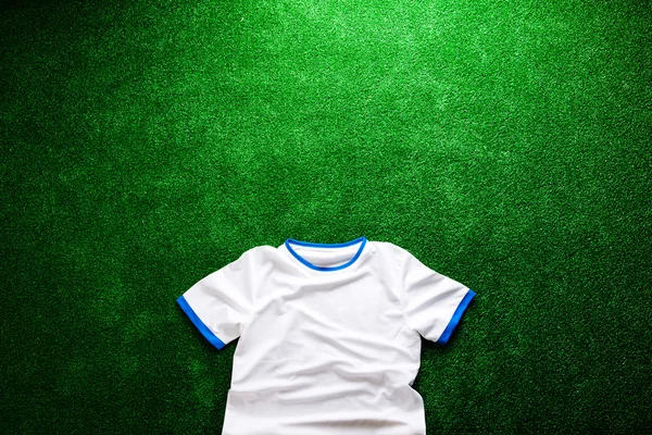 Sports t-shirt against artificial turf. Studio shot. Copy space.