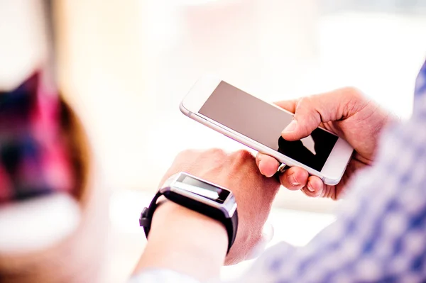 Onherkenbaar man thuis met behulp van smartphone en slimme horloge — Stockfoto