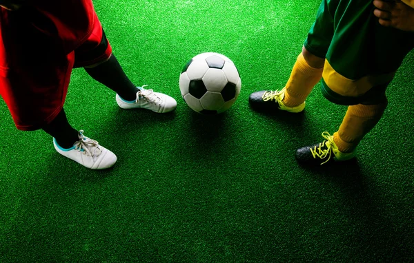 Zwei nicht wiederzuerkennende kleine Fußballer gegen grünen Rasen — Stockfoto