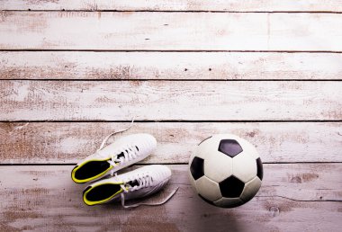 Futbol topu, beyaz ahşap zemin üzerinde kramponlar, stüdyo atış