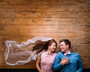 Genç çift ahşap arka plan karşı bir katta yalan