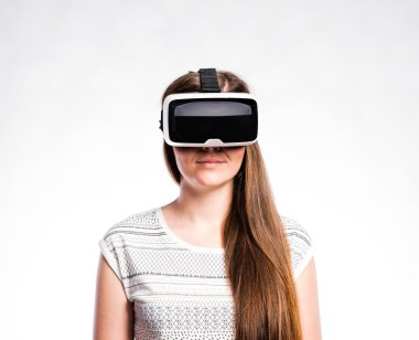 Sanal gerçeklik gözlüklü bir kadın. Stüdyo çekimi, gri arkaplan