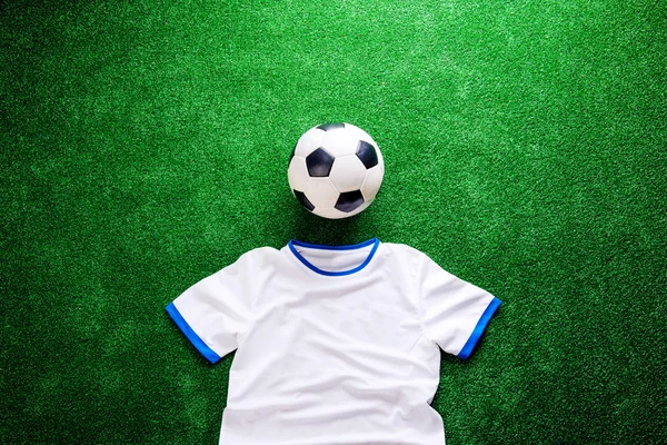 Pallone da calcio e t-shirt bianca contro tappeto erboso artificiale — Foto Stock