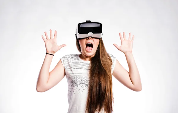 Žena s brýlemi pro virtuální realitu. Studio záběr, šedé pozadí — Stock fotografie