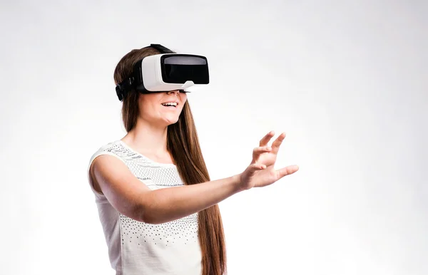 Mujer con gafas de realidad virtual. Estudio de tiro, fondo gris — Foto de Stock