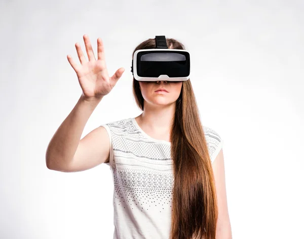 Mujer con gafas de realidad virtual. Estudio de tiro, fondo gris —  Fotos de Stock
