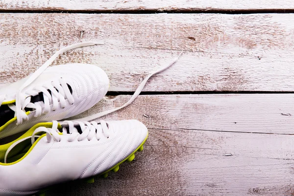 Scarpe da calcio su sfondo di legno. Colpo in studio. Copia spazio . — Foto Stock