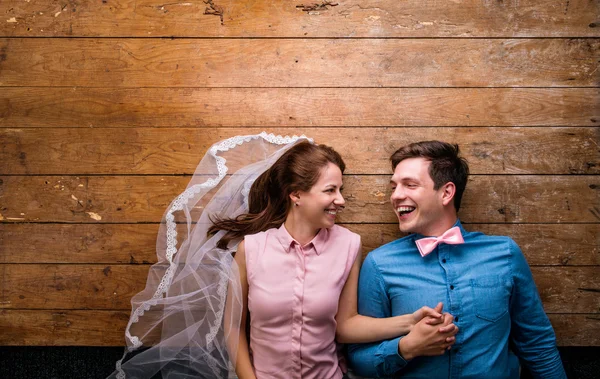 Genç çift ahşap arka plan karşı bir katta yalan