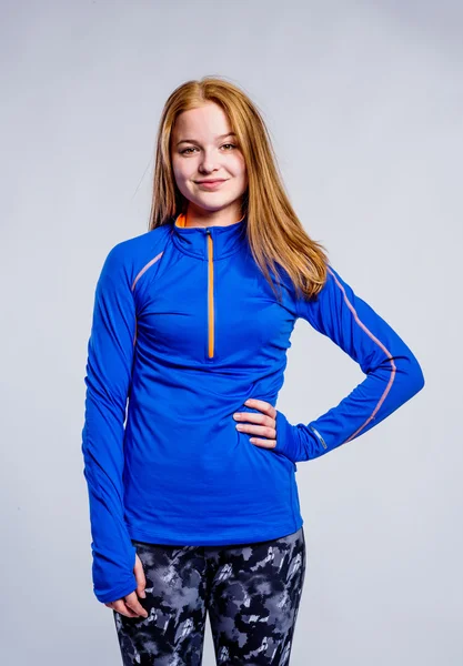 Girl in blue sweatshirt and fitness leggings, studio shot — Stock Photo, Image