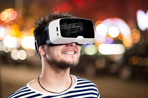 Exposição dupla, homem vestindo óculos de realidade virtual, cidade noturna — Fotografia de Stock