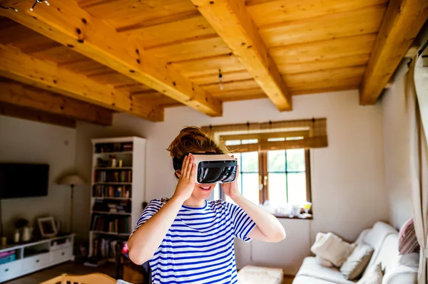 Kobieta ubrana wirtualnej rzeczywistości gogle stoi w salonie — Zdjęcie stockowe