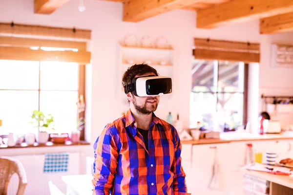 Man wearing virtual reality goggles standing in a kitchen — Stock Photo, Image