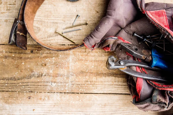 Borsa da falegnami con cintura piena di attrezzi, fondo in legno — Foto Stock