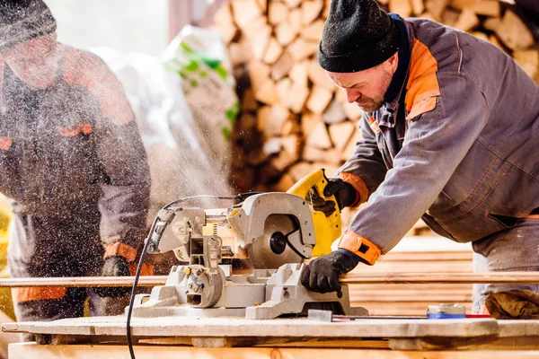 Carpenter working. Man cutting plank by circular saw. — Stock Photo, Image