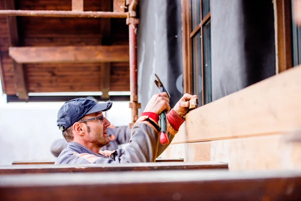 Bauarbeiter wärmeisoliert Haus, macht Holzfassade — Stockfoto