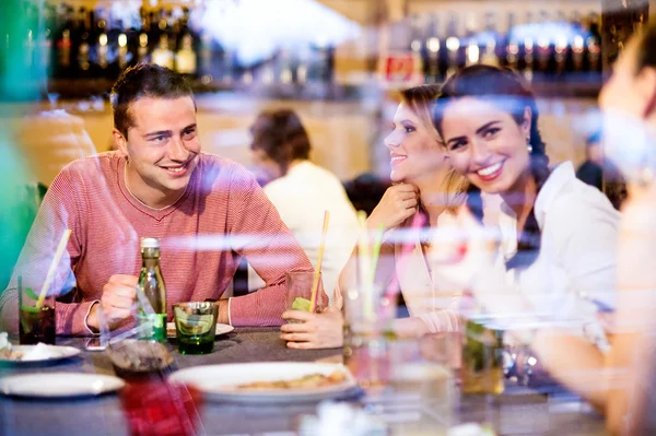 Gyönyörű a fiatalok a koktélokat a bárban vagy klubban — Stock Fotó
