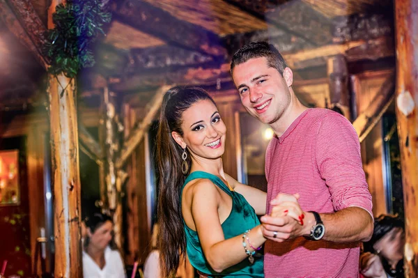 Young beautiful couple dancing in bar or club — Zdjęcie stockowe