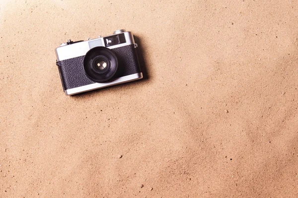 Cámara vintage contra playa de arena. Grabado en estudio. Copiar espacio . — Foto de Stock