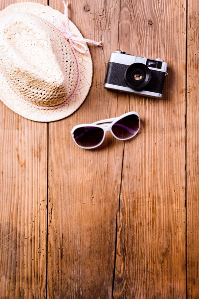 Gafas de sol, sombrero y cámara vintage sobre fondo de madera . —  Fotos de Stock