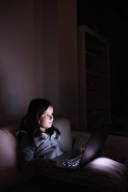 Laptop ile oynarken bir karanlıkta oturup küçük kız