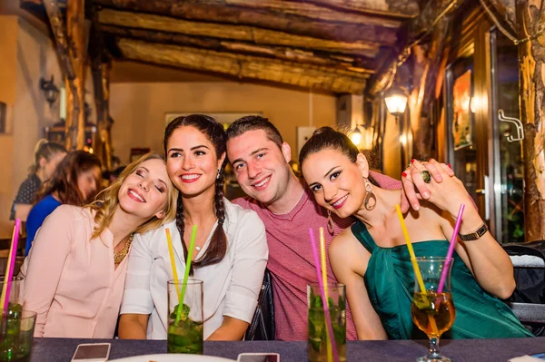 Young beautiful people with cocktails in bar or club — Stock Photo, Image