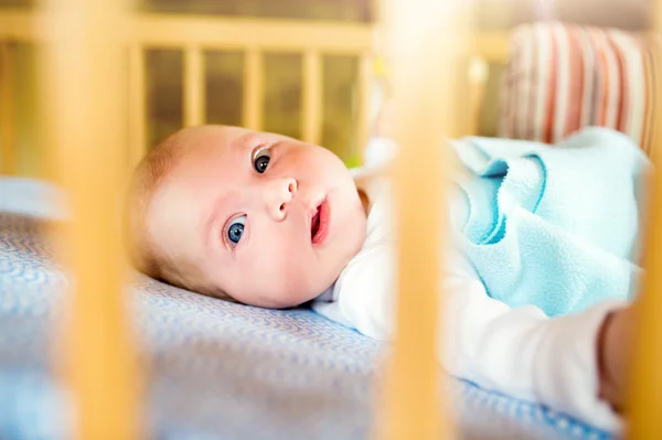 Little baby boy lying in wooden crib, close up — Stock Photo, Image