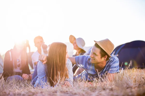 Teenagers lying on the ground in front of tents — Stock Photo, Image