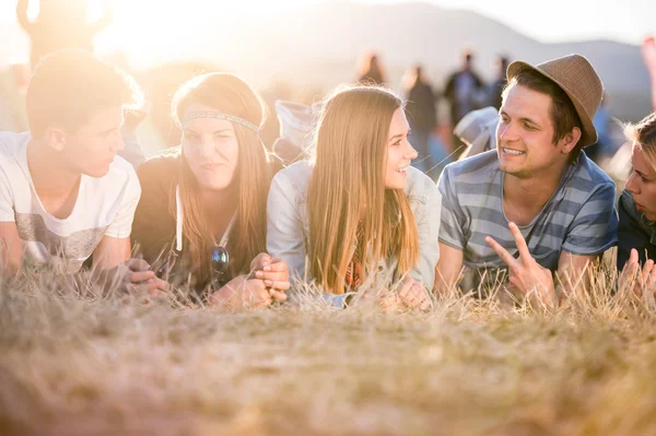 Teenagers lying on the ground in front of tents — Stock Photo, Image