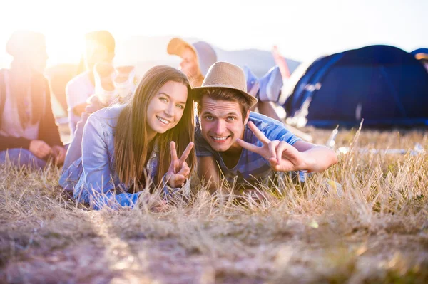 Teenagers lying on the ground in front of tents — Stock Photo, Image